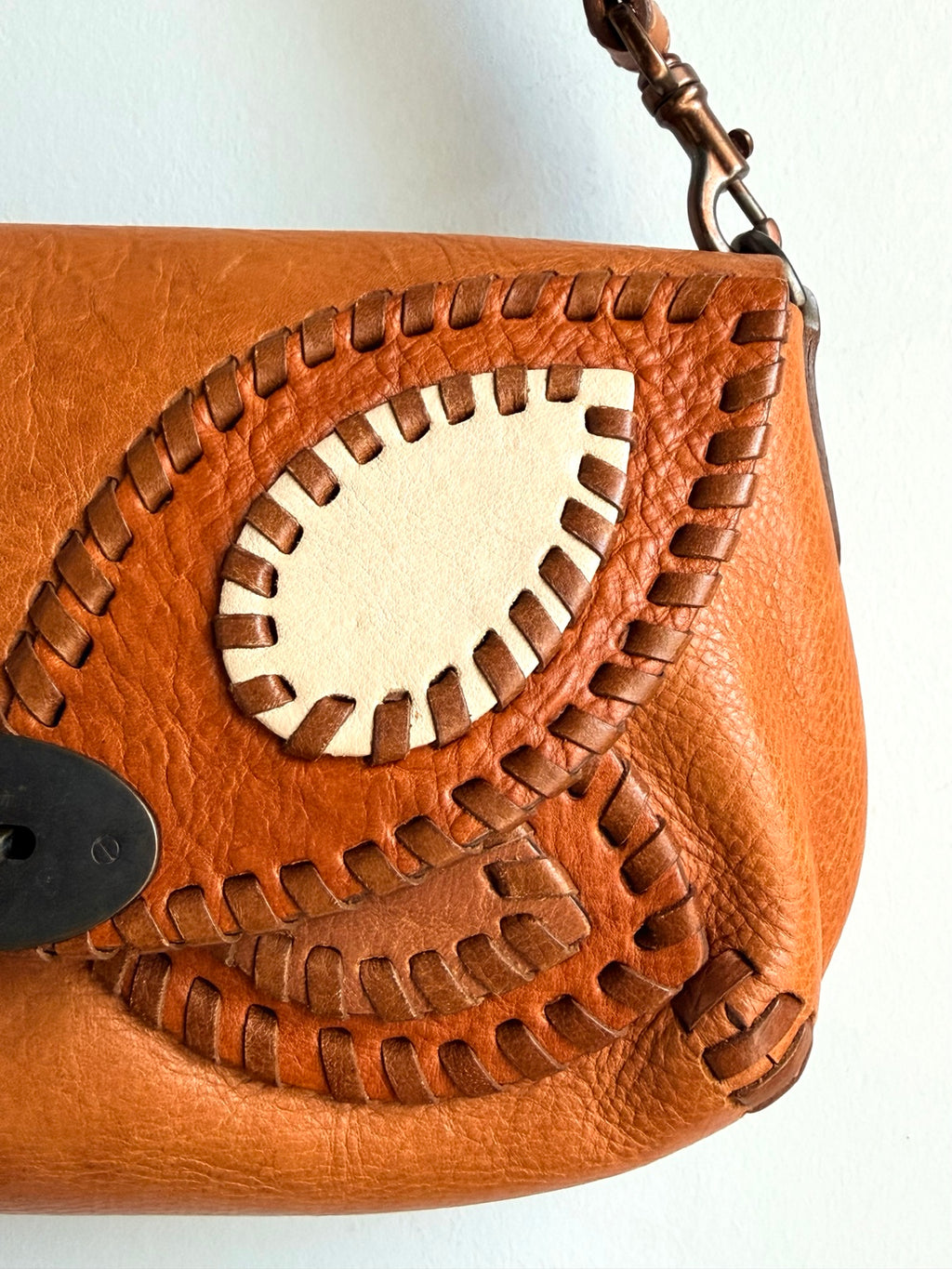 Whipstitched butterfly appliqué detail in oak and cream leather
