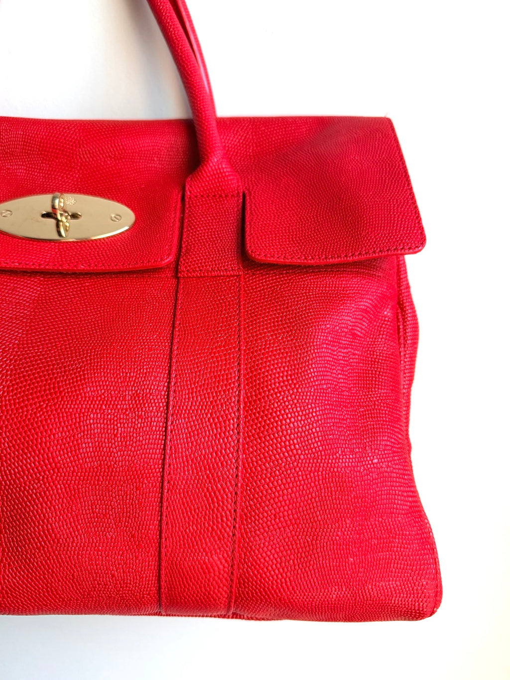 Close-up of bright red lizard-print leather and gold-tone lock on Mulberry Bayswater