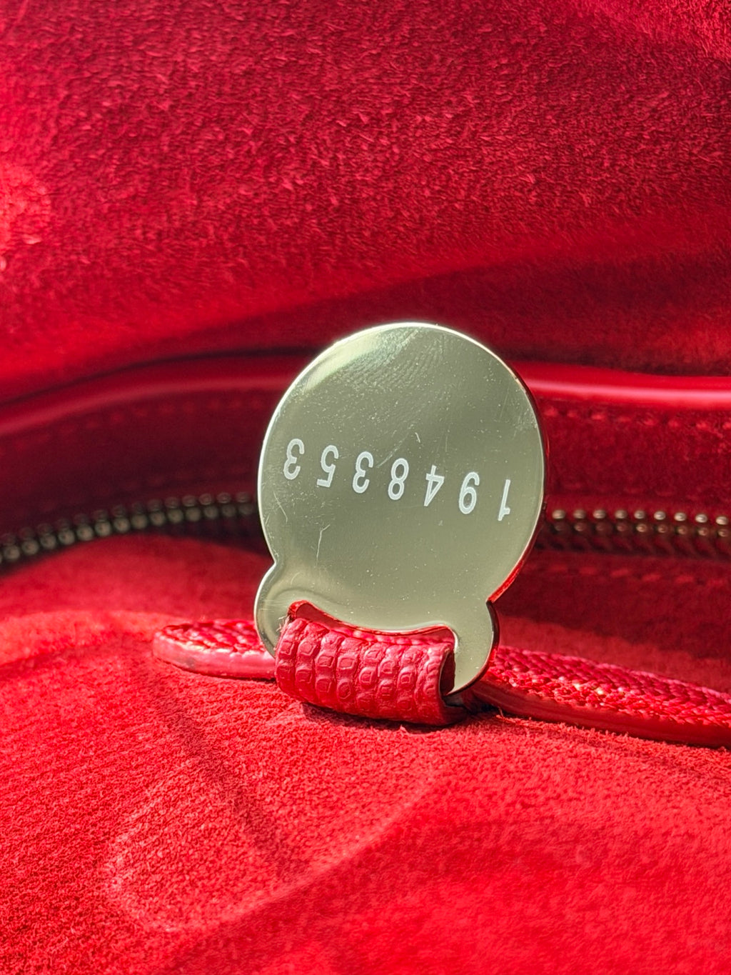 Numbered metal disc inside red Mulberry Bayswater